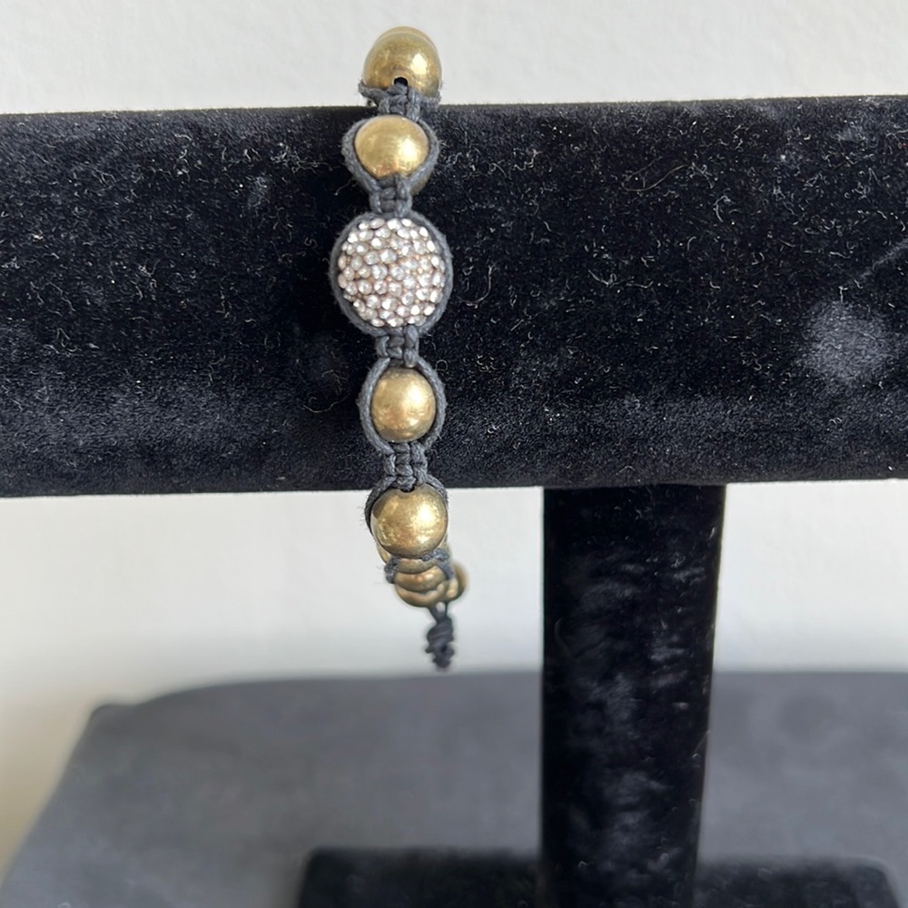 Gold tone bracelet on black cord - Picture 1 of 2